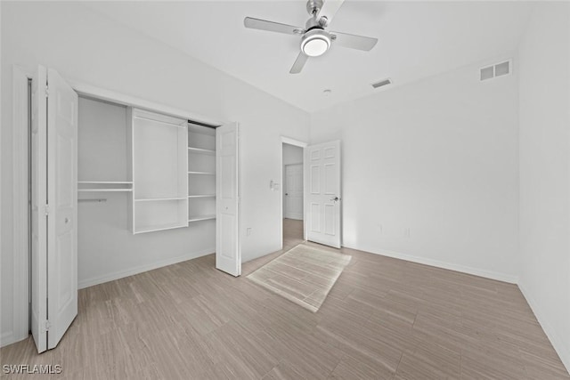 unfurnished bedroom featuring ceiling fan, light hardwood / wood-style floors, and a closet