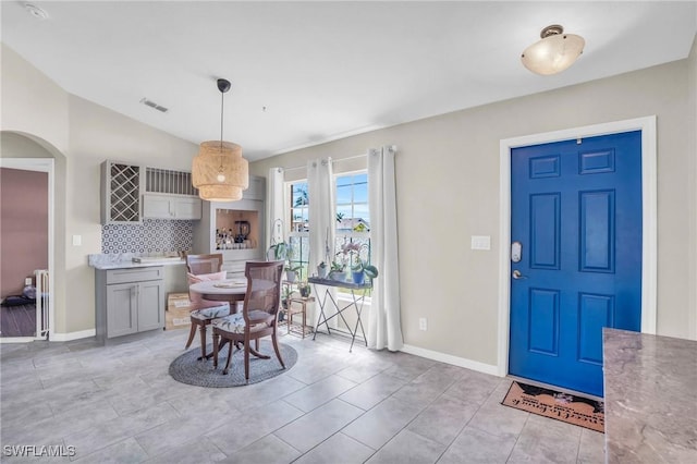 dining area with vaulted ceiling and light tile patterned flooring