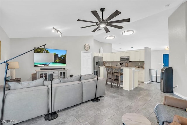 living room featuring vaulted ceiling and ceiling fan