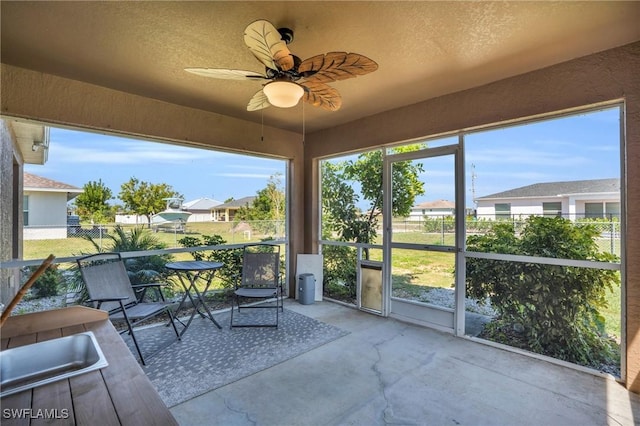 sunroom / solarium featuring ceiling fan