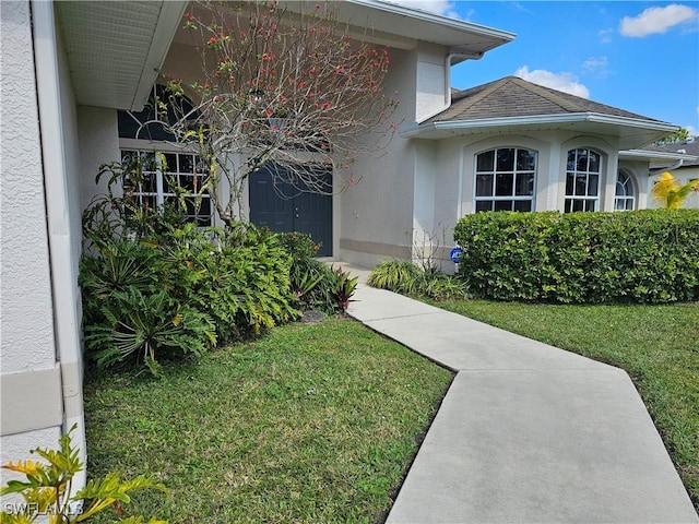 property entrance featuring a lawn