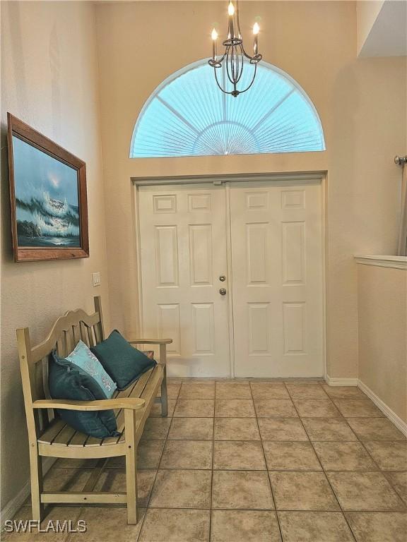 entryway with an inviting chandelier and tile patterned floors