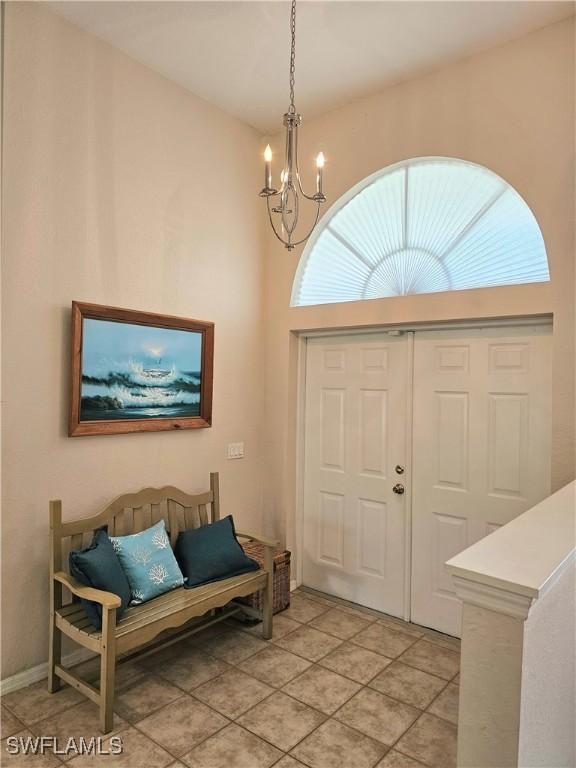 foyer featuring light tile patterned floors and a chandelier