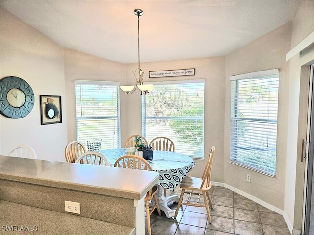 dining area with tile patterned flooring and vaulted ceiling