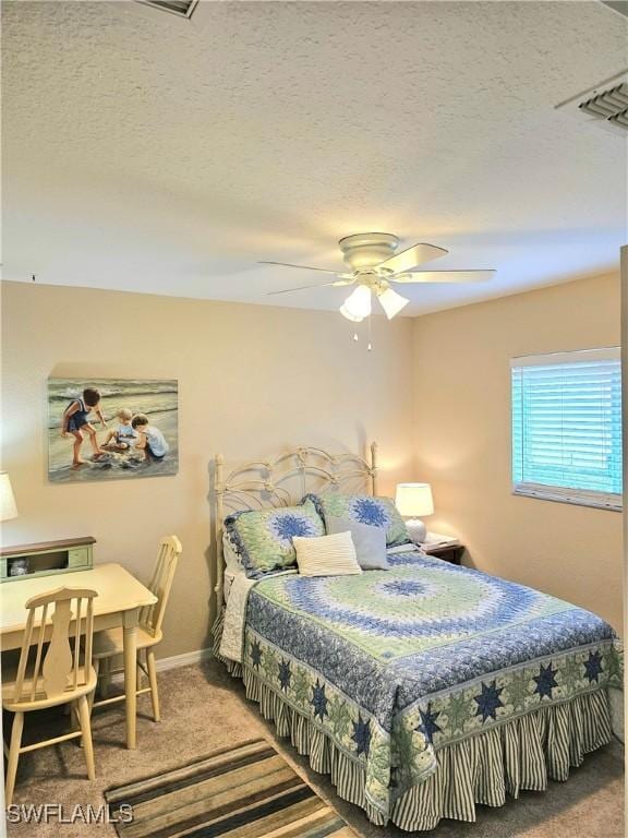 carpeted bedroom featuring ceiling fan and a textured ceiling