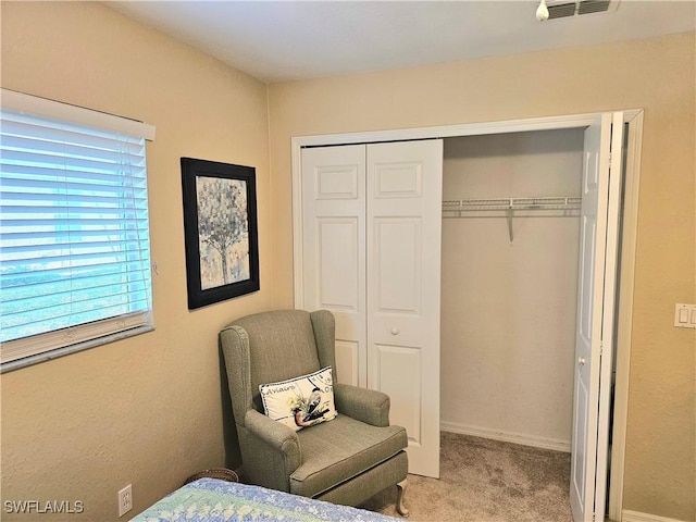 bedroom featuring light colored carpet and a closet