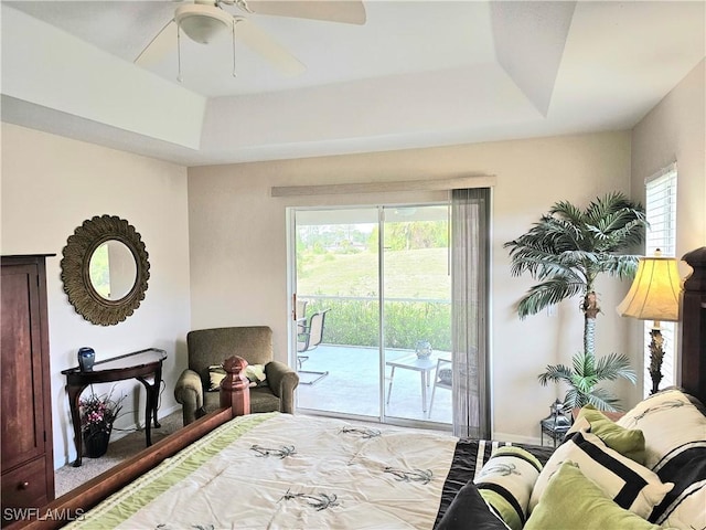 bedroom with a tray ceiling, access to outside, and ceiling fan