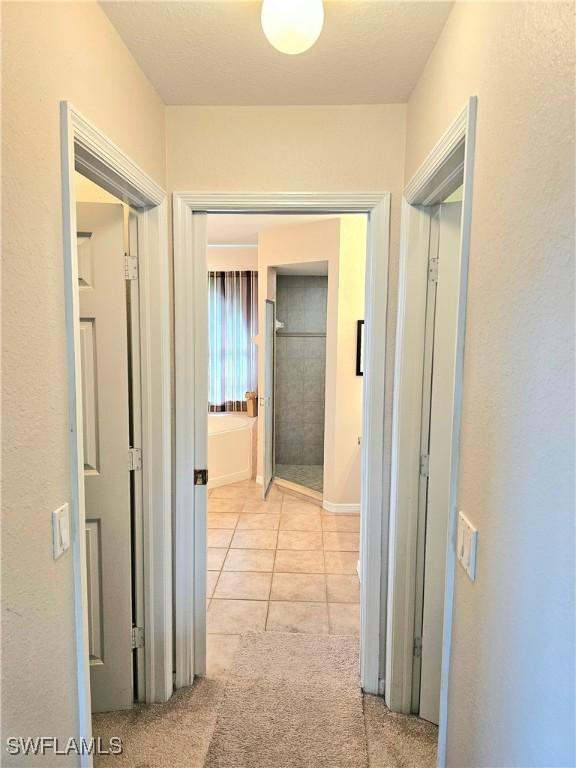 hall featuring light tile patterned floors