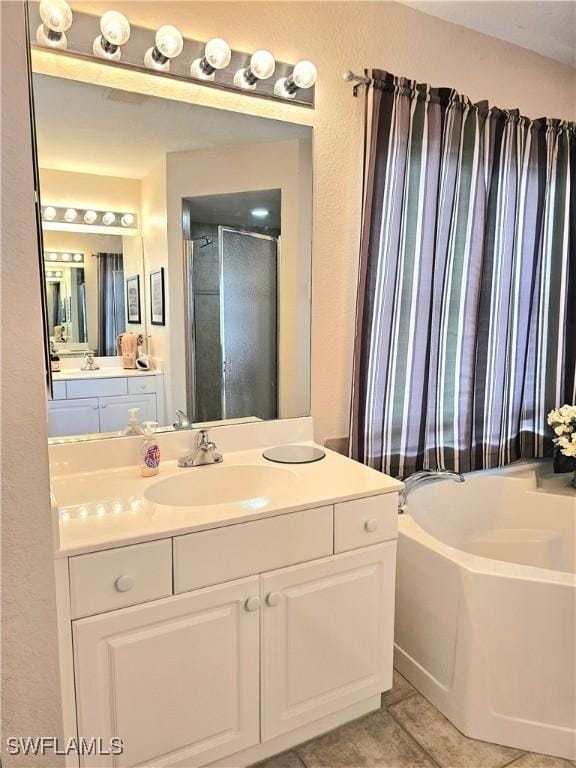 bathroom featuring independent shower and bath, vanity, and tile patterned floors