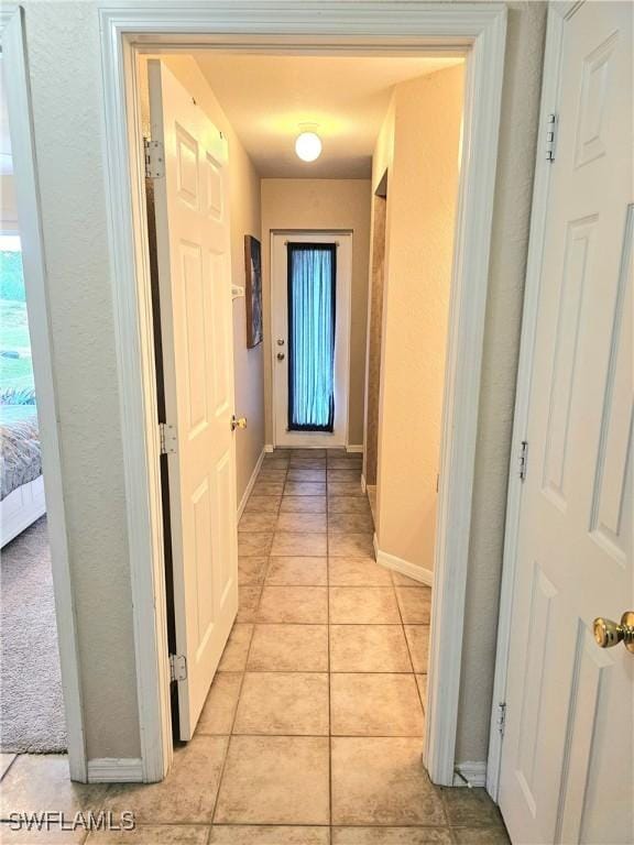 hall with light tile patterned floors