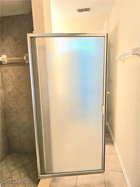 bathroom featuring an enclosed shower and tile patterned floors