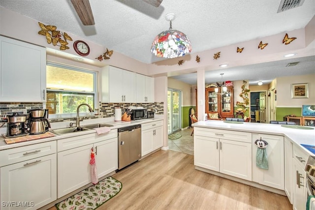 kitchen featuring sink, white cabinetry, decorative light fixtures, stainless steel dishwasher, and light wood-type flooring