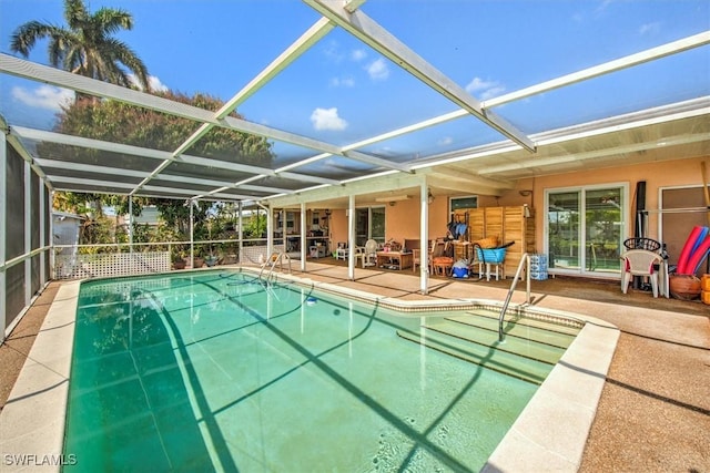 view of swimming pool featuring glass enclosure and a patio area