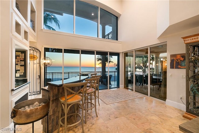 sunroom with bar area and a water view