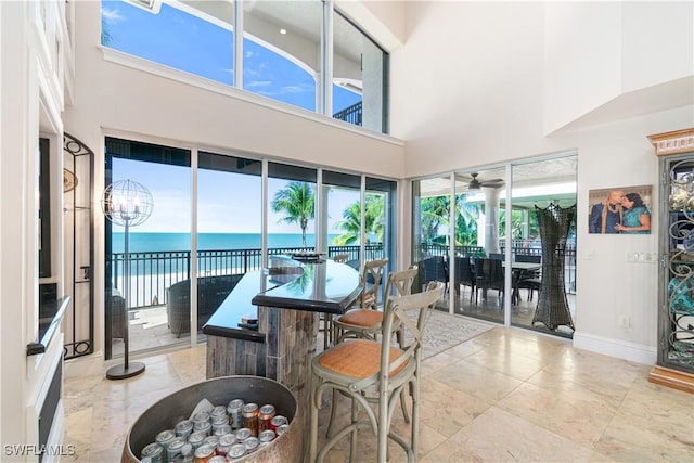 interior space with an inviting chandelier, a high ceiling, and a water view