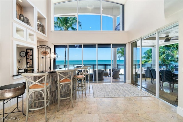 interior space featuring a water view, ceiling fan, and a healthy amount of sunlight