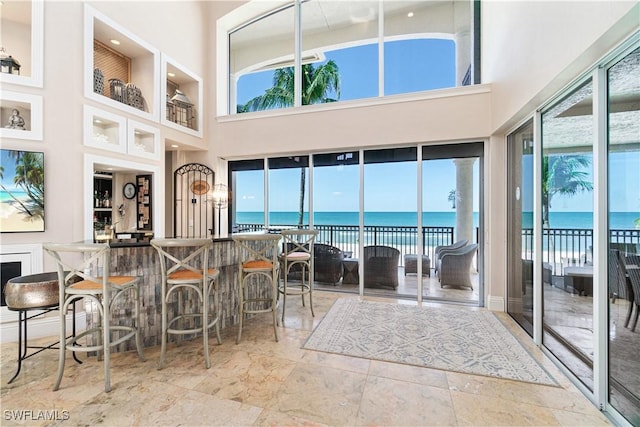 sunroom / solarium featuring a water view and a wealth of natural light