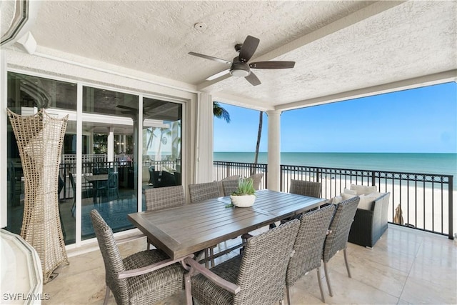 sunroom featuring a water view, a beach view, and ceiling fan