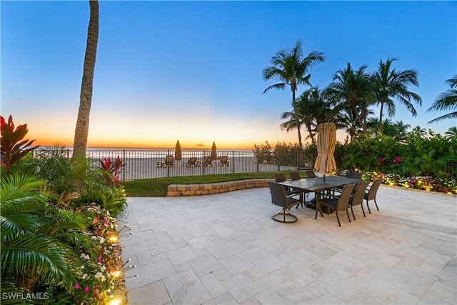 patio terrace at dusk featuring a water view