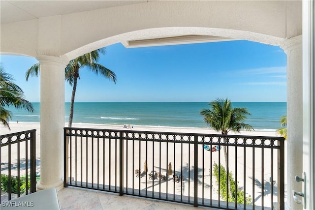 balcony featuring a beach view and a water view