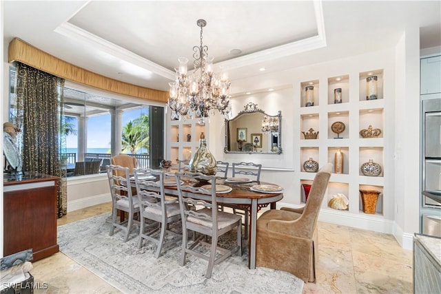 dining area with a raised ceiling, crown molding, and built in shelves