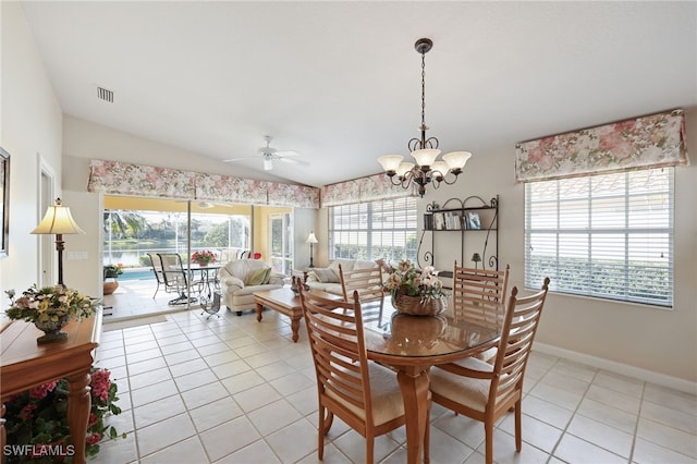 dining room with light tile patterned floors, ceiling fan with notable chandelier, and vaulted ceiling