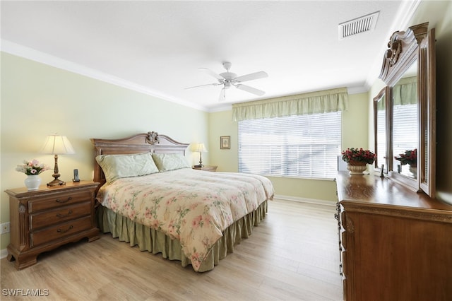 bedroom with multiple windows, ornamental molding, ceiling fan, and light hardwood / wood-style flooring