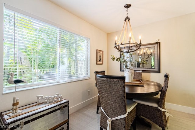 dining space featuring a chandelier and baseboards