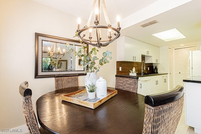 dining area featuring visible vents and an inviting chandelier