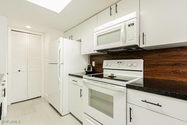 kitchen featuring white appliances, decorative backsplash, dark countertops, white cabinetry, and recessed lighting