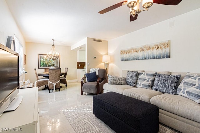 living room with baseboards, visible vents, and ceiling fan with notable chandelier