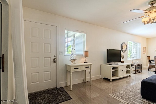 foyer with a ceiling fan and baseboards