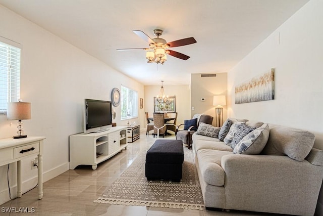 living room featuring ceiling fan with notable chandelier, visible vents, and baseboards