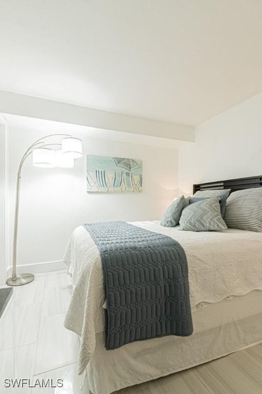 bedroom featuring baseboards and light wood finished floors