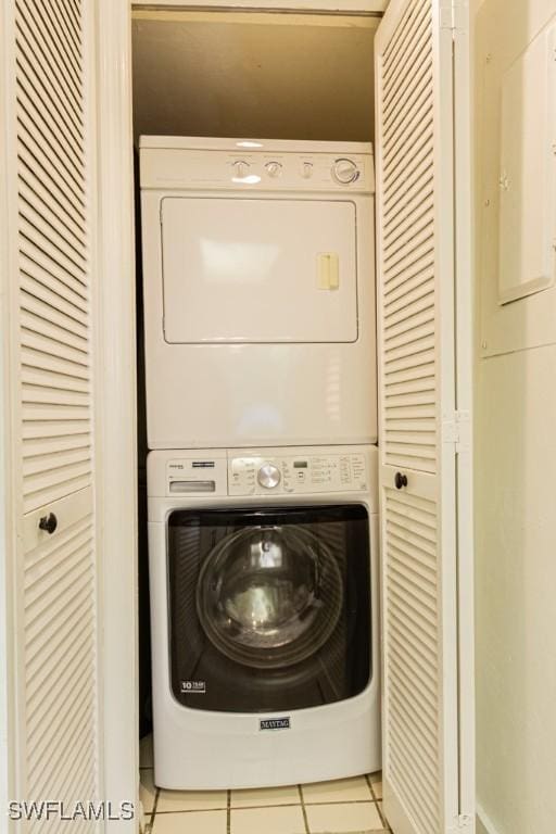 laundry room with laundry area, stacked washing maching and dryer, and light tile patterned floors