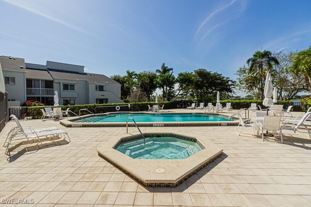 community pool featuring a patio and a hot tub