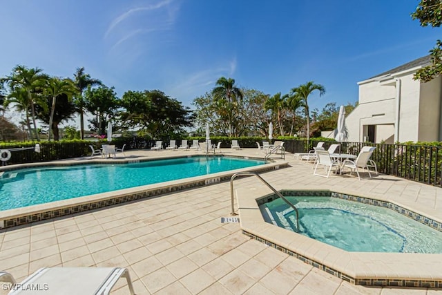 community pool featuring a patio area, fence, and a community hot tub