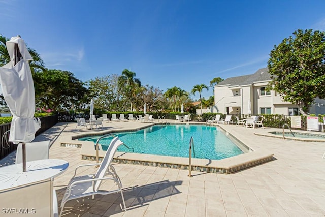 pool featuring a patio area, a hot tub, and fence