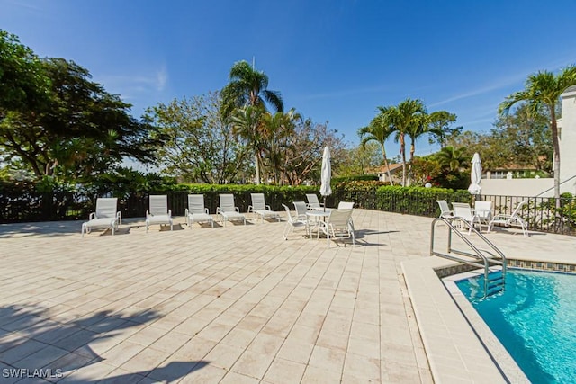 community pool featuring a patio area and fence