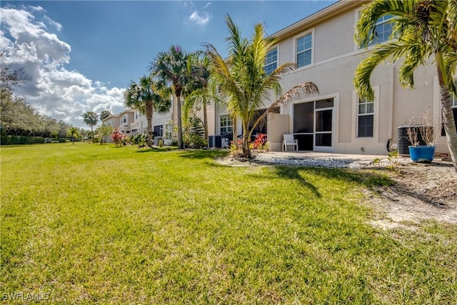 back of property featuring central AC and a lawn