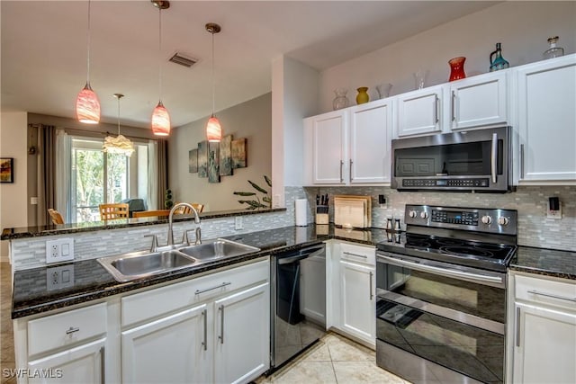 kitchen featuring sink, appliances with stainless steel finishes, white cabinetry, decorative light fixtures, and dark stone counters