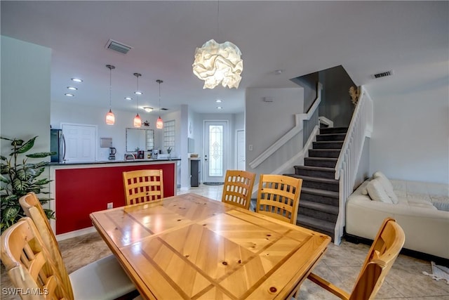 tiled dining area featuring a chandelier