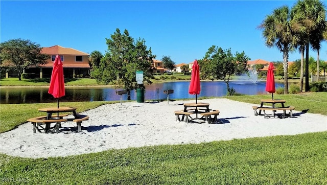 view of home's community featuring a water view and a lawn