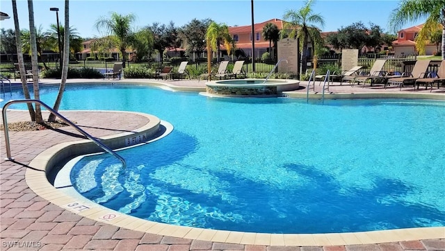 view of pool with a hot tub