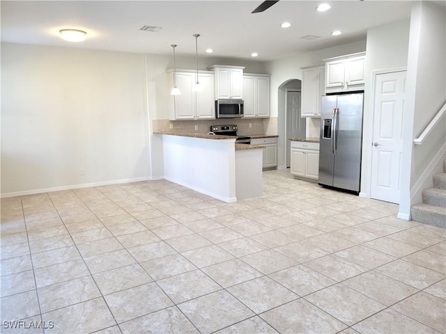 kitchen with decorative light fixtures, appliances with stainless steel finishes, kitchen peninsula, ceiling fan, and white cabinets