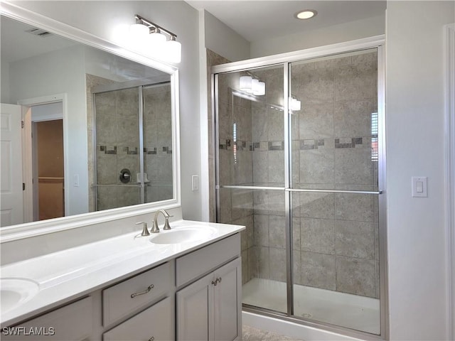 bathroom with vanity and a shower with door