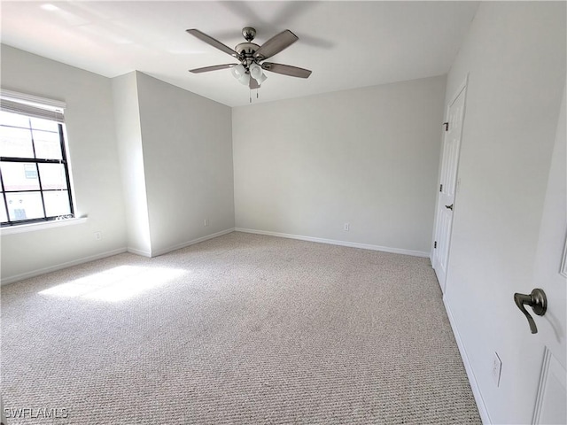 carpeted spare room with ceiling fan