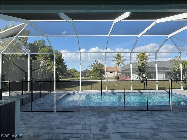 view of swimming pool featuring a yard, a lanai, and a patio