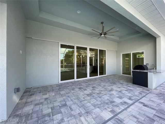 view of patio with area for grilling, sink, and ceiling fan