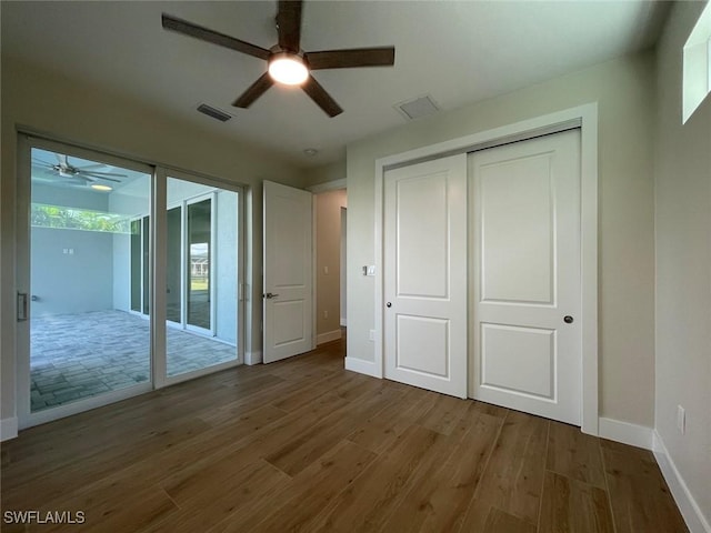 unfurnished bedroom with hardwood / wood-style flooring, access to outside, a closet, and ceiling fan